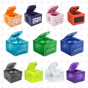 May include: A selection of multi-coloured retro game consoles, including orange, purple, pink, blue, green, and black. Each console has an open lid, revealing the internal components. The consoles are arranged in a grid pattern.