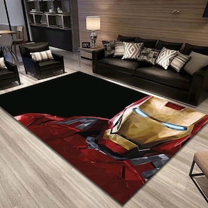 Könnte beinhalten: Ein schwarzer und roter Teppich mit einem geometrischen Muster von Iron Mans Gesicht. Der Teppich befindet sich in einem Wohnzimmer mit einer Couch und Stühlen.