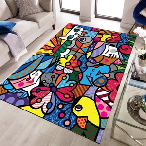 Pu&ograve; includere: Un tappeto colorato con un motivo geometrico che presenta una farfalla, un pesce e un gatto. Il tappeto ha un design luminoso e audace con un mix di rosso, giallo, blu, verde e nero.