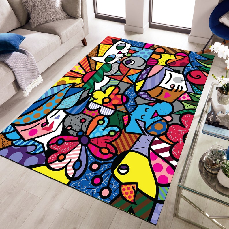 Pu&ograve; includere: Un tappeto colorato con un motivo geometrico che presenta una farfalla, un pesce e un gatto. Il tappeto ha un design luminoso e audace con un mix di rosso, giallo, blu, verde e nero.