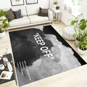 May include: Black and white rug with a cloud design and the text "KEEP OFF" printed in white. The rug is designed by IKEA c/o Virgil AblohTM.