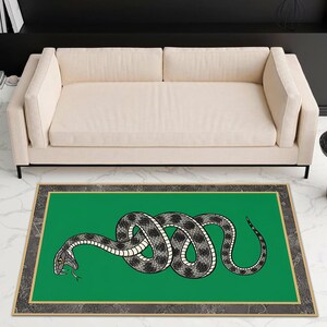 May include: A rectangular area rug featuring a vibrant green center field with a coiled, black and white patterned snake illustration. The rug is framed by a thin gold border and a wide, dark gray marble-textured outer border with a white vein pattern.