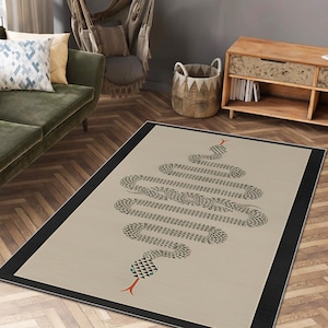 Peut inclure: Un tapis rectangulaire au fond beige avec une bordure noire. Le centre présente un grand motif de serpent stylisé composé de petits triangles noirs, avec une langue fourchue rouge distincte et des accents verts sur la tête.