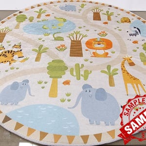 May include: A round, cream-colored play rug with a jungle theme. The rug features a variety of animals, including tigers, elephants, a giraffe, and a lion. There are also trees, plants, and a blue pond on the rug. The rug has a brown and tan border with a repeating triangle pattern.