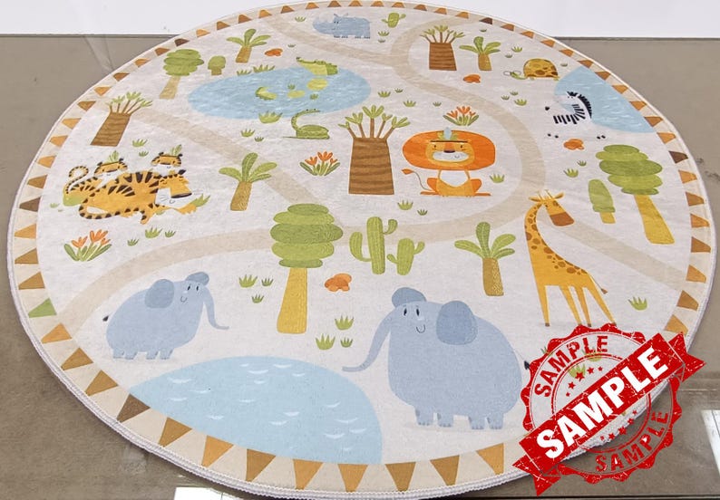 May include: A round, cream-colored play rug with a jungle theme. The rug features a variety of animals, including tigers, elephants, a giraffe, and a lion. There are also trees, plants, and a blue pond on the rug. The rug has a brown and tan border with a repeating triangle pattern.