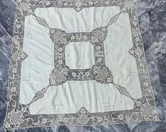 May include: A white tablecloth with a delicate lace border. The lace features a floral design with intricate details. The tablecloth is perfect for a formal dinner or special occasion.