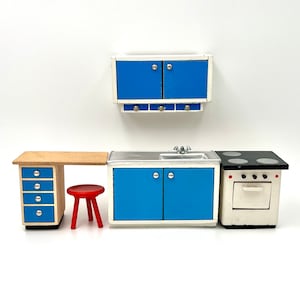 May include: A miniature blue and white kitchen set with a sink, stove, and cabinets. The set includes a small red stool and a wooden counter with drawers.