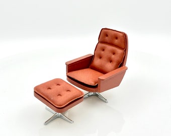 May include: A brown leather armchair with a matching ottoman. The chair has a swivel base and tufted upholstery.