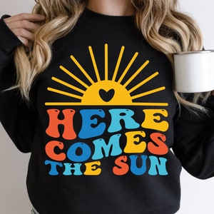 グルーヴィーなレトロな「Here Comes The Sun」SVG PNG昇華、レトロなサマーシャツデザイン、グルーヴィーな女子旅、夏が来るバケーションのオーシャンバイブスPNG