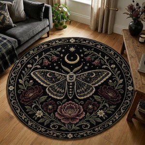 Pode incluir: Tapete redondo preto com um desenho de traça, lua crescente e estrelas. A traça é rodeada por elementos florais e botânicos em bordô, creme e verde. O tapete tem uma borda decorativa.