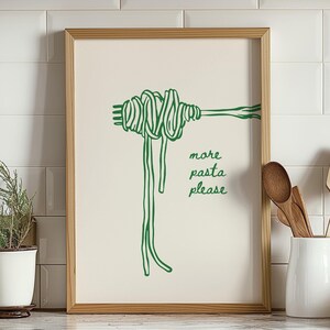 Peut inclure: Une impression encadr&eacute;e blanche avec un dessin au trait vert d'une fourchette avec un paquet de p&acirc;tes dessus. Le texte "more pasta please" est &eacute;crit sous les p&acirc;tes.
