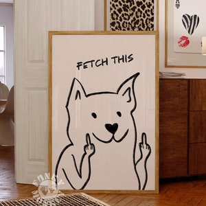 Könnte beinhalten: Ein weißer gerahmter Druck mit einer Schwarzweißillustration eines Hundes, der den Mittelfinger zeigt. Der Text "FETCH THIS" steht über dem Hund.