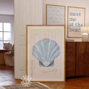 May include: A blue and white watercolour illustration of a seashell on a postcard with the text "The sea is calling..." and "PLACE STAMP HERE".