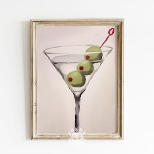 Peut inclure: Une peinture d'un verre &agrave; martini avec trois olives vertes et un cure-dent rouge. Le verre est rempli d'un liquide clair et l'arri&egrave;re-plan est de couleur rose p&acirc;le.
