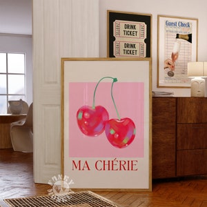 Puede incluir: Una impresi&oacute;n enmarcada con un fondo rosa y dos cerezas rojas. El texto "MA CH&Eacute;RIE" est&aacute; impreso en rojo en la parte inferior de la impresi&oacute;n.