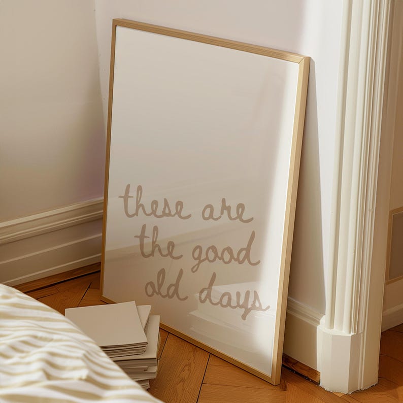May include: A framed print with a gold frame and a white background. The print features the text "these are the good old days" in a light brown colour.