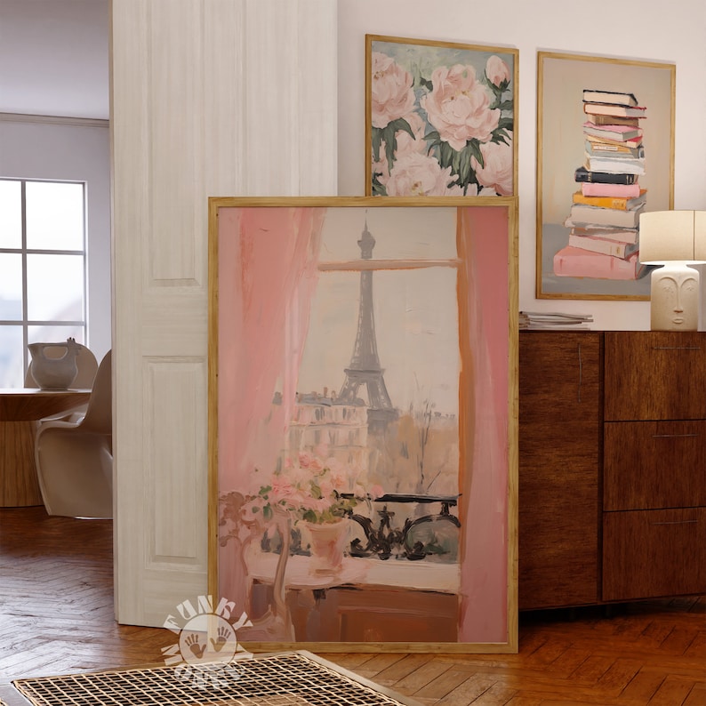 May include: A framed painting of a window view of the Eiffel Tower in Paris, France. The window is decorated with pink curtains and there are pink flowers in a vase on the windowsill. The painting is in a wooden frame.