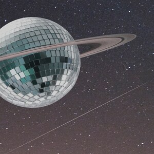May include: A silver disco ball with a ring around it, set against a dark blue background with white stars.