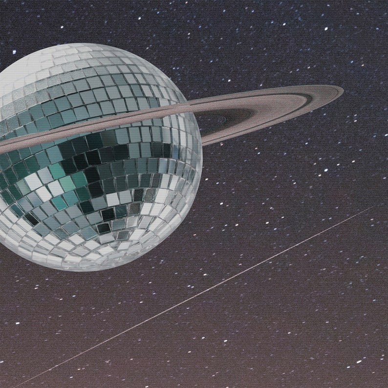 May include: A silver disco ball with a ring around it, set against a dark blue background with white stars.
