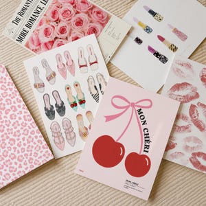 May include: A collection of illustrated art prints featuring various designs including a pink leopard print, a bouquet of pink roses, assorted luxury footwear, lipsticks, red lip prints, and a pink card with two cherries and the text MON CHERI.