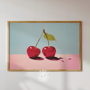 May include: Two red cherries with green stems and a single green leaf on a light blue and pink background.