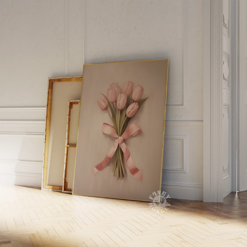 May include: A framed print of a bouquet of pink tulips tied with a pink ribbon. The background is a light beige color.