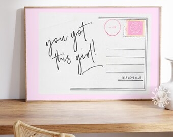 May include: A pink and white framed print with the text "you got this girl!" and "SELF LOVE CLUB" in black script. The print is designed to look like a vintage postcard with a pink heart stamp.