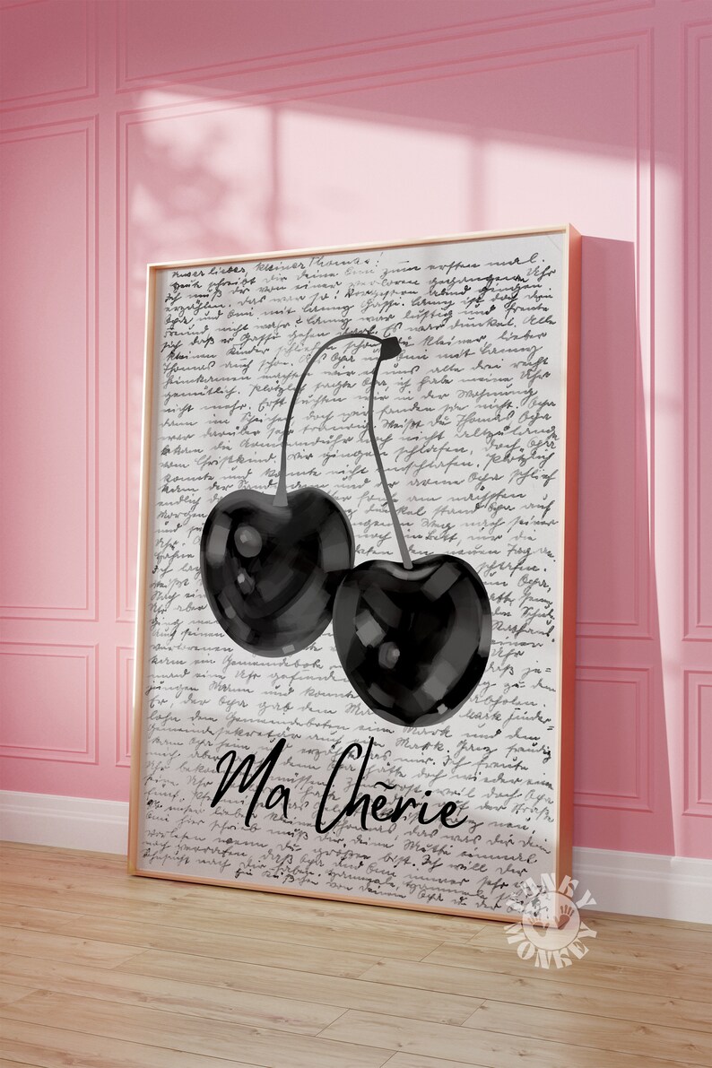 May include: A black and white illustration of two cherries with stems on a white background with handwritten text that says "Ma Cherie".
