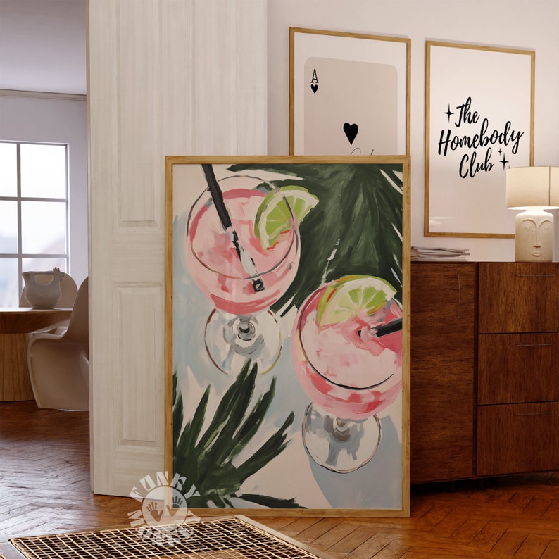 May include: Two pink cocktails with lime wedges and straws in tall glasses, painted in a stylized, abstract style against a background of green palm leaves and a light blue sky.