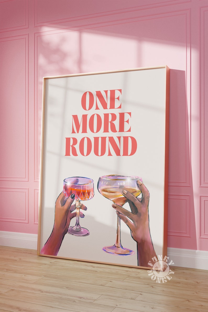 Peut inclure: Une affiche blanche avec le texte "ONE MORE ROUND" en lettres roses. Deux mains tiennent des verres de vin, l'un avec du vin rouge et l'autre avec du vin blanc.