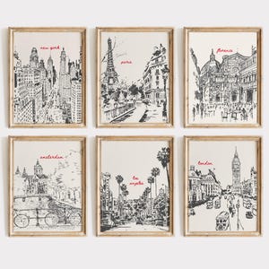 May include: Set of six black and white framed prints featuring hand-drawn illustrations of famous landmarks in cities around the world. The prints include New York, Paris, Florence, Amsterdam, Los Angeles, and London.