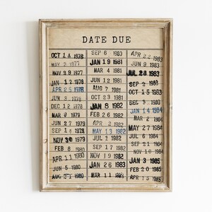 May include: A framed wall print featuring a vintage library date due card design on a beige background. The print displays the text DATE DUE at the top, followed by three columns of stamped dates ranging from 1976 to 1985 in black and blue ink.