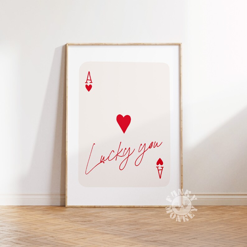 Op de afbeelding: Een printable poster met een rode harten aas speelkaart met de tekst "Lucky you" geschreven in cursief.
