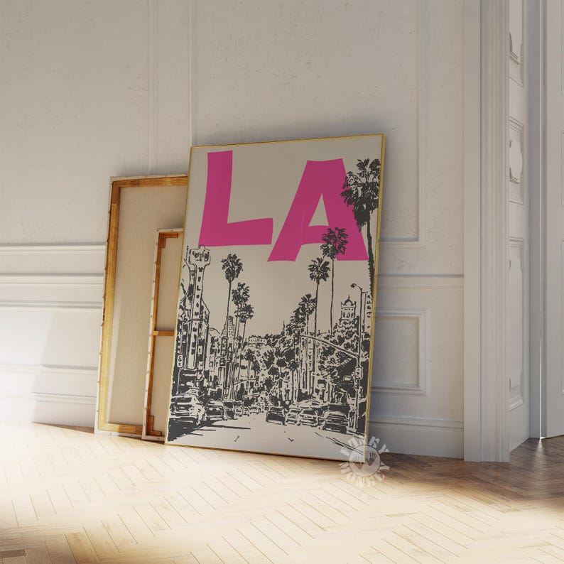 May include: A black and white illustration of a city street with palm trees and the word 'LA' in pink letters on a beige background.