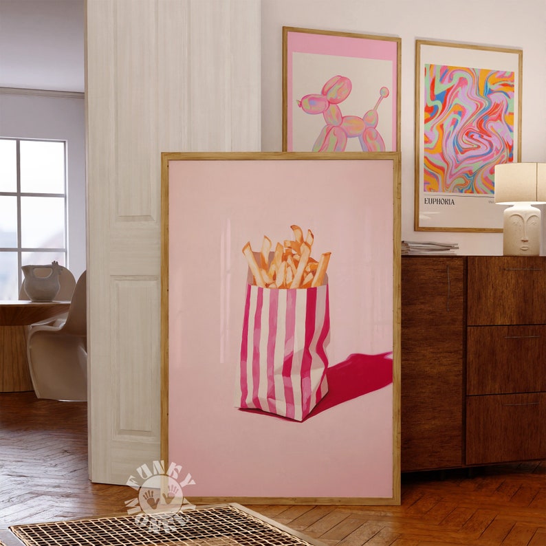 May include: A pink and white striped paper bag filled with golden french fries on a pink background.