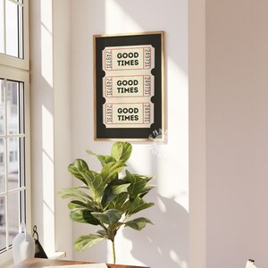 May include: A black framed print with three vintage ticket stubs that read "Good Times" in a pink font. The print is hanging on a white wall.