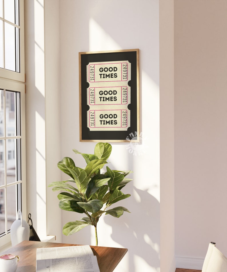 May include: A black framed print with three vintage ticket stubs that read "Good Times" in a pink font. The print is hanging on a white wall.