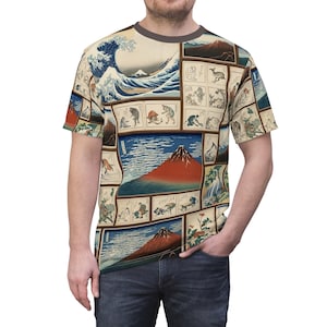 Puede incluir: Una camiseta de manga corta con un estampado integral de varias obras de arte japonesas en xilografía, incluyendo la Gran Ola de Kanagawa, múltiples representaciones del monte Fuji en tonos rojos y azules, y pequeños paneles con figuras.