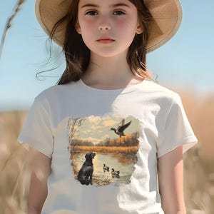 Retro duck hunting tshirt featuring a black lab and mallard ducks by a pond, printed outdoors scene for babies, kids, and adults, perfect for hunting families and dog lovers.