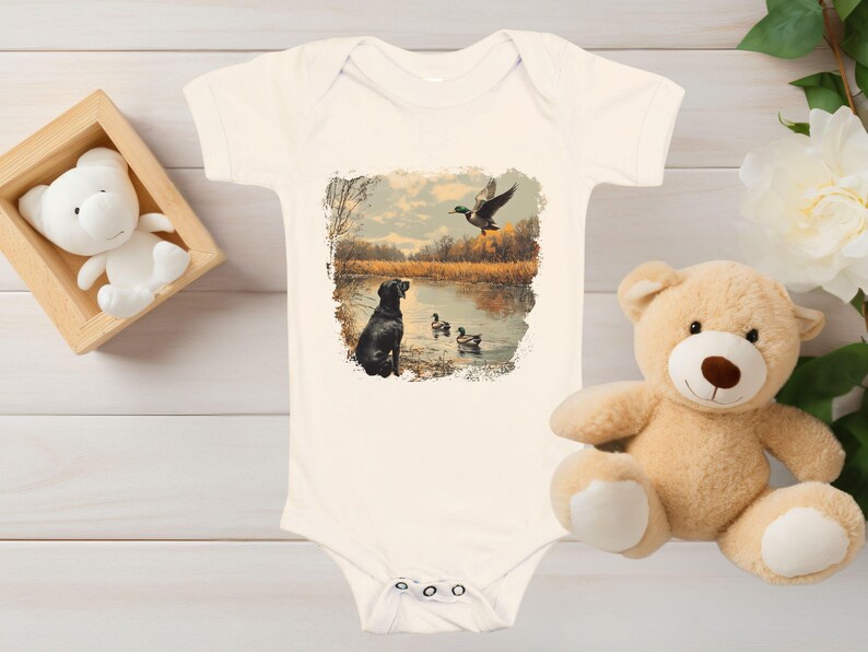 Retro duck hunting baby bodysuit featuring a black lab and mallard ducks by a pond, printed outdoors scene for babies, kids, and adults, perfect for hunting families and dog lovers.