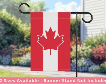 Könnte beinhalten: Eine rot-weiße kanadische Gartenflagge mit einem weißen Ahornblatt. Die Flagge ist an einem schwarzen Metall-Gartenflaggenmast befestigt.
