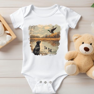 Retro duck hunting baby bodysuit featuring a black lab and mallard ducks by a pond, printed outdoors scene for babies, kids, and adults, perfect for hunting families and dog lovers.