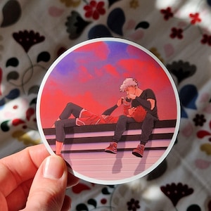 May include: Two figures sit on a striped bench against a red and purple sunset. The figure on the left is laying back with their head resting on the lap of the figure on the right. The figure on the right is wearing a black shirt and jeans. The figure on the left is wearing a red and black shirt and black pants.