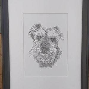 May include: A black framed print of a dog's face, drawn in a stippled style using tiny dots.