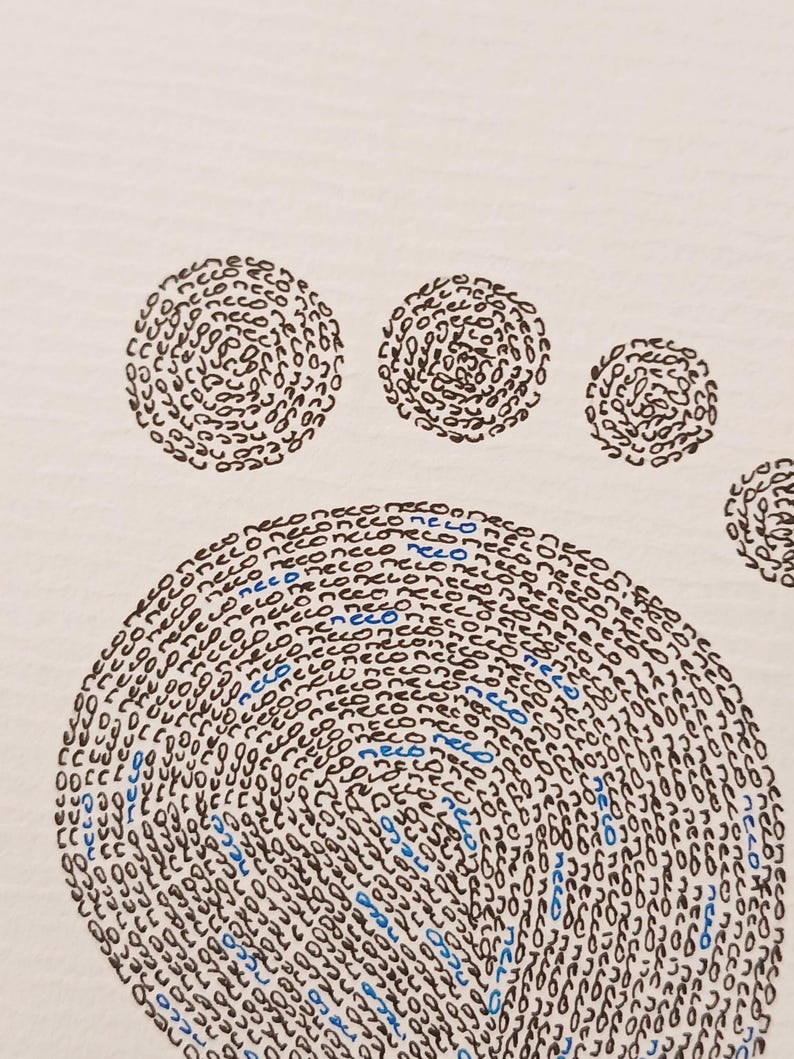 Detail van de de teentjes van een babyvoetje gemaakt met handgeschreven woorden in zwart en blauw.