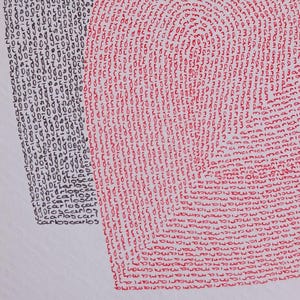 Op de afbeelding: Een detailfoto van twee harten in rood en zwart . De linkerkant gebruikt zwarte tekst "carlos" terwijl de rechterkant rode tekst "maria" gebruikt om het hart op een witte achtergrond te vormen.