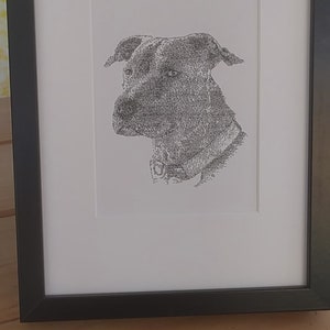 May include: A black and white framed print of a dog's head, created using a stippling technique.