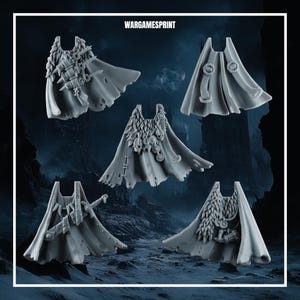 May include: A set of five grey miniature capes for tabletop gaming figures, each featuring unique details like fur collars, skulls, runes, swords, and straps. The text WARGAMESPRINT is displayed at the top of the image above the collection.