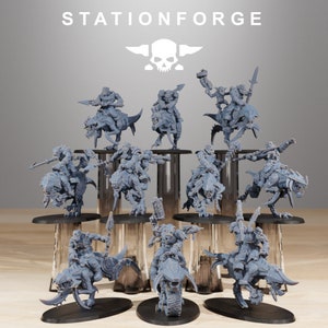 May include: A collection of 12 grey 3D printed miniature figures of orcs riding various creatures. The figures are posed in dynamic action poses and are set on a wooden table.