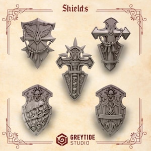 May include: Five different 3D printed shield designs, each with a unique and intricate design. The shields are made of a light gray plastic and feature various symbols, including crosses, skulls, and wings. The shields are labeled "Shields" at the top of the image.